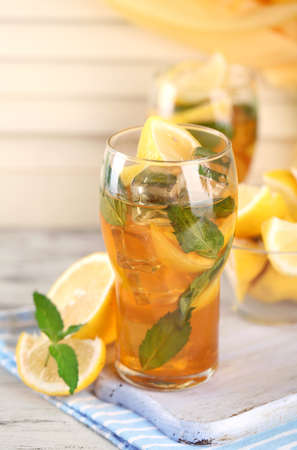 Iced tea with lemon and mint on wooden tableの写真素材