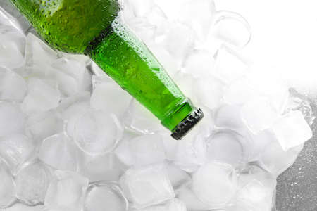 Bottle of beer with ice cubes, close upの写真素材