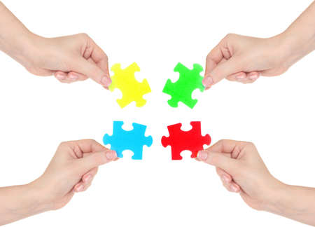 Four hands holding colorful puzzle, isolated on whiteの写真素材