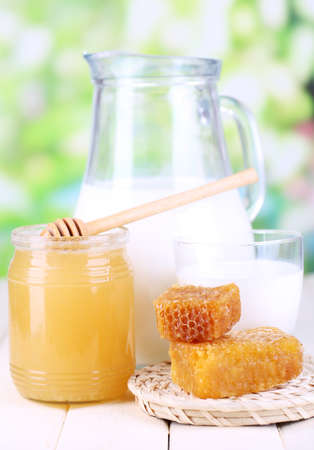 Honey and milk on wooden table on natural backgroundの写真素材