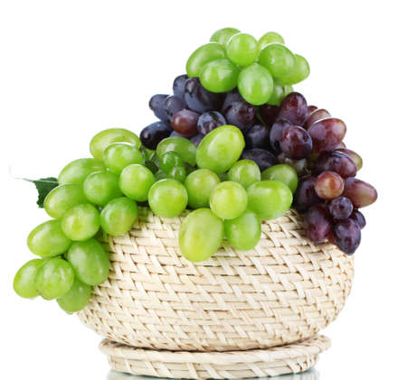Ripe green and purple grapes in basket isolated on whiteの写真素材