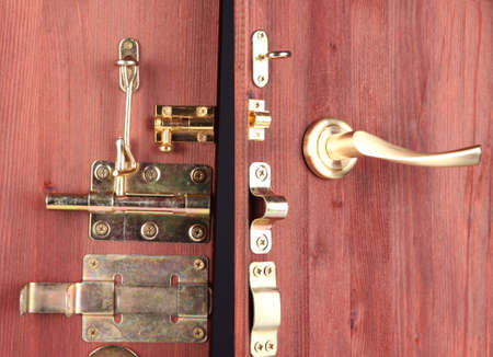 Metal bolts, latches and hooks in wooden open door close-upの写真素材