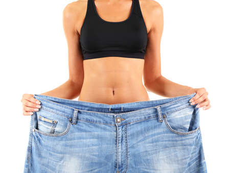 Slim girl with big jeans isolated on whiteの写真素材