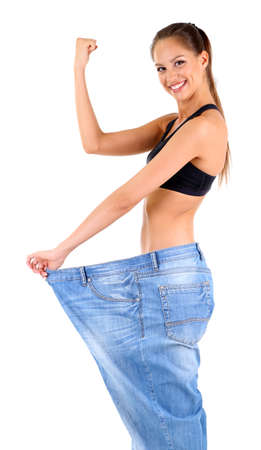 Slim girl in big jeans isolated on whiteの写真素材