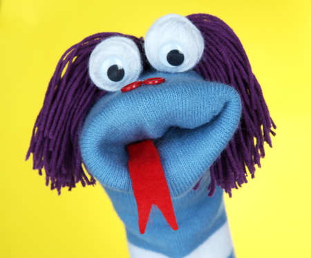 Cute sock puppet on yellow backgroundの写真素材