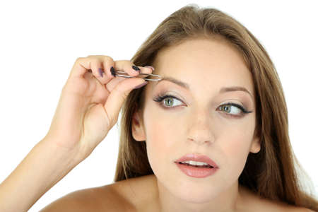 Young woman plucking eyebrows isolated on whiteの写真素材