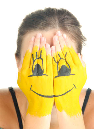 Portrait of girl hiding her face under smile mask isolated on whiteの写真素材
