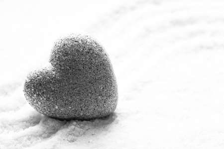 Grey zen stone in shape of heart, on sand backgroundの写真素材