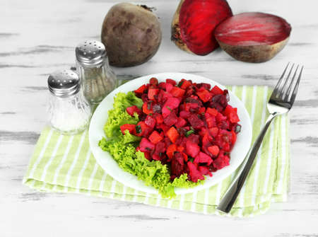 Beet salad on plate on napkin on wooden table の写真素材