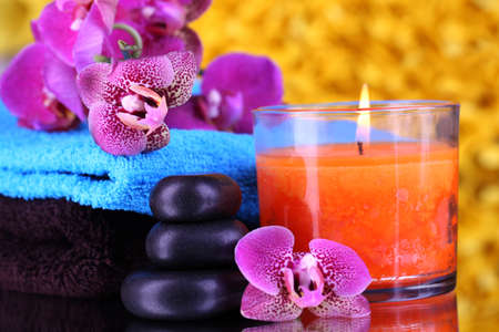 Beautiful spa setting with orchid on yellow backgroundの写真素材