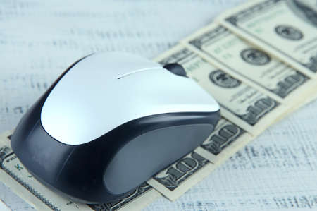 Computer mouse on dollars on wooden backgroundの写真素材