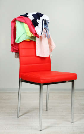 Heap of  clothes on color chair,  on gray backgroundの写真素材