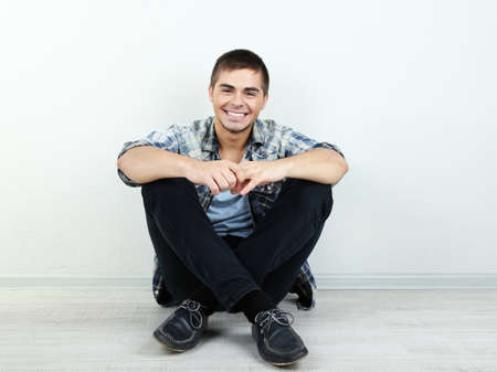Guy sitting on floor in roomの写真素材