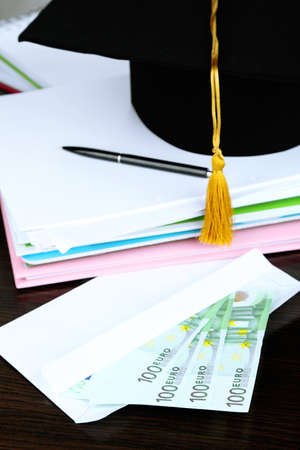 Money for graduation or training on wooden table close-upの写真素材