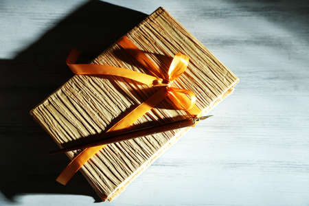Book wrapped with color ribbon, on color wooden  backgroundの写真素材