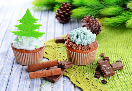 Tasty cupcakes with butter cream, on color wooden backgroundの写真素材