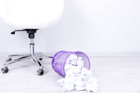 Recycle bin filled with crumpled papers, on floorの写真素材