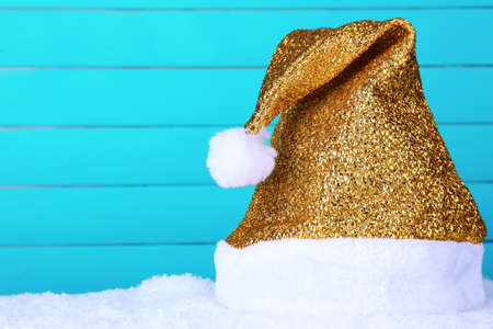 Santa hat on snow on color wooden の写真素材