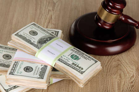 Stacks of money and judges gavel on wooden tableの写真素材