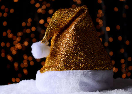 Santa hat on snow on lights backgroundの写真素材