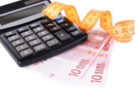 Tape measure with money and calculator isolated on whiteの写真素材