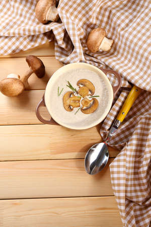 Mushroom soup in pot, on napkin,  on wooden backgroundの写真素材