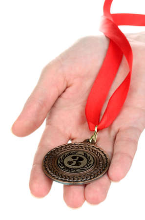 Bronze medal in hand isolated on whiteの写真素材