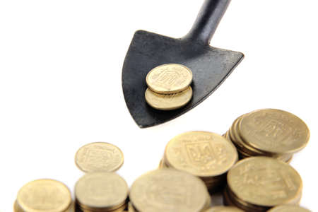 Coins with shovel isolated on whiteの写真素材