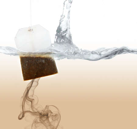 Tea bag dipped in hot waterの写真素材