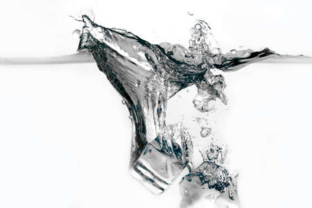 Ice cubes splashing into water isolated on whiteの写真素材