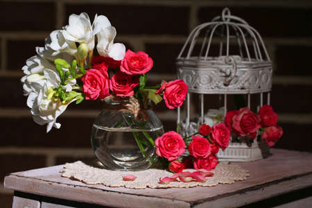 Beautiful still life with small pink roses and freesia flowersの写真素材