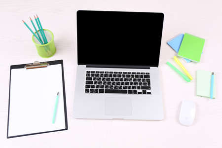 Office workplace with open laptop on wooden deskの写真素材