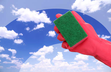 Hand with sponge cleaning dirty windowの写真素材