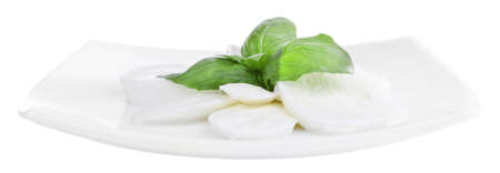 Tasty mozzarella cheese with basil on plate isolated on whiteの写真素材
