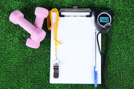 Sheet of paper and sports equipment on grass close-upの写真素材