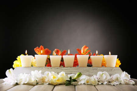 Beautiful candles with flowers on wooden backgroundの写真素材