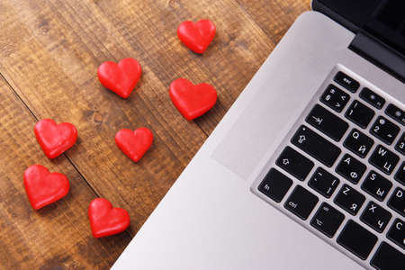 Computer with red hearts on table close upの写真素材