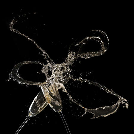 Glasses of champagne with splash, on black backgroundの写真素材