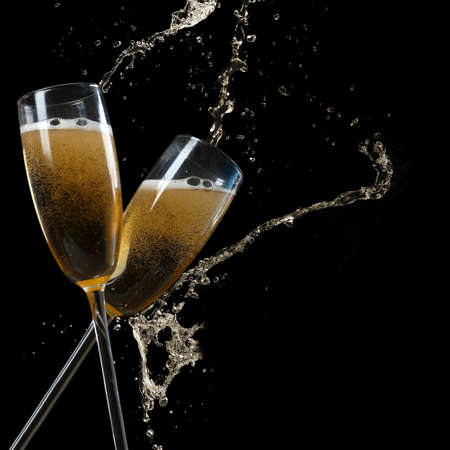 Glasses of champagne with splash, on black backgroundの写真素材