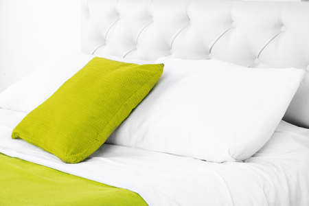 Comfortable soft bed with pillows in roomの写真素材