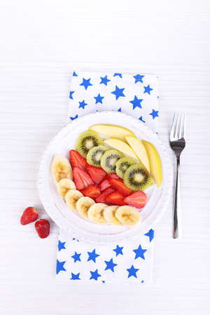 Various sliced fruits on plate on table close-upの写真素材