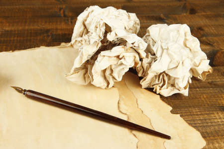 Crumpled paper balls with ink pen and envelopes on wooden backgroundの写真素材