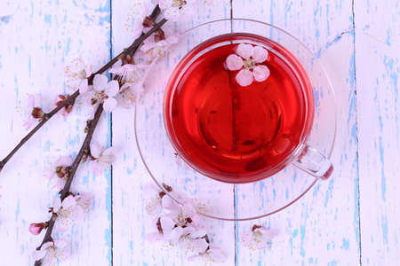 Fragrant tea with flowering branches on wooden table close-upの写真素材