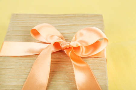Book wrapped with color ribbon, on color backgroundの写真素材