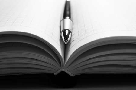 Pen on opened book, close upの写真素材