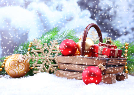 Composition with Christmas decorations in basket, fir tree on light backgroundの写真素材