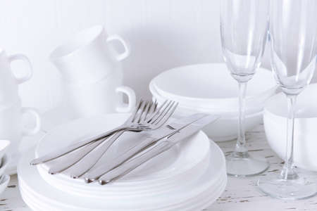 Set of white dishes on table on light backgroundの写真素材