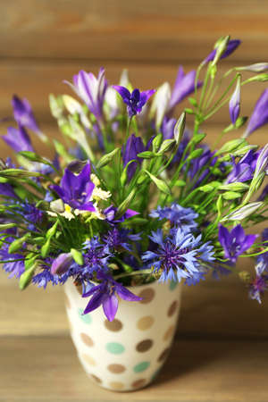 Beautiful wild flowers on table on wooden backgroundの写真素材