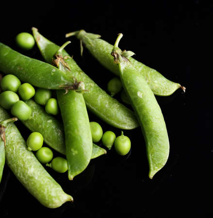 Fresh green peas isolated on black backgroundの写真素材