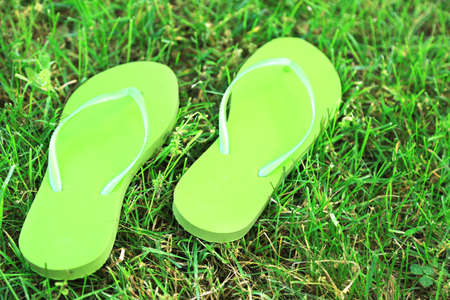 Bright flip-flops on green grass の写真素材